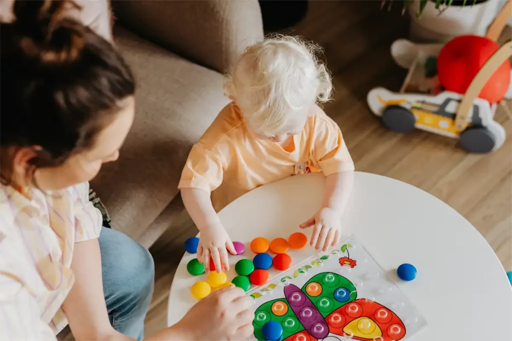 Mother watching daughter play at a table